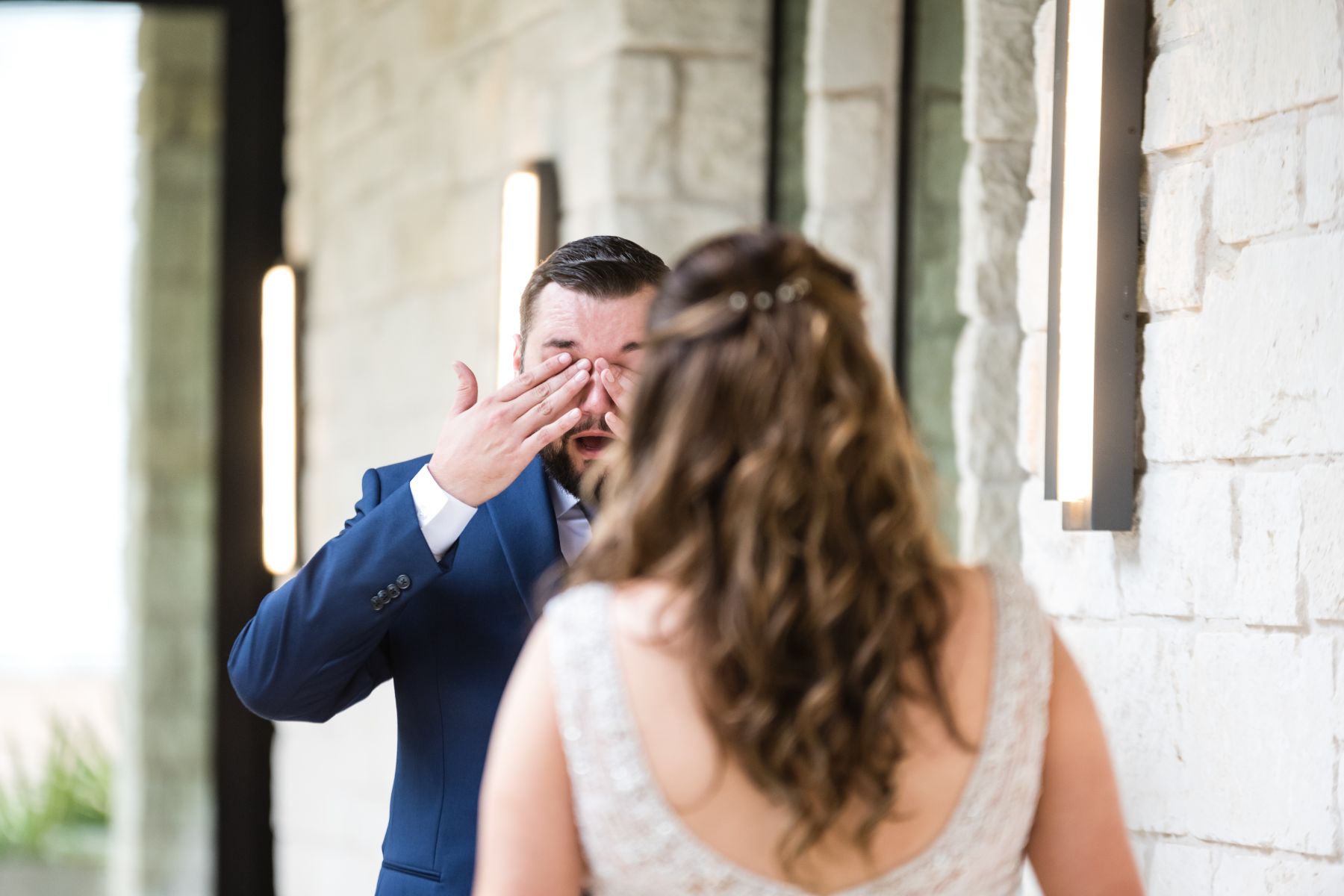 Groom is wiping his tears from his eyes as he takes a first look of his bride on their wedding day at Stonehouse Villa.